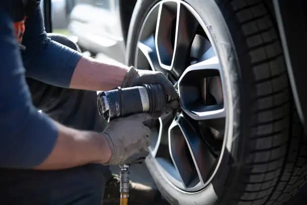 Technician removing a vehicle wheel during tire assistance